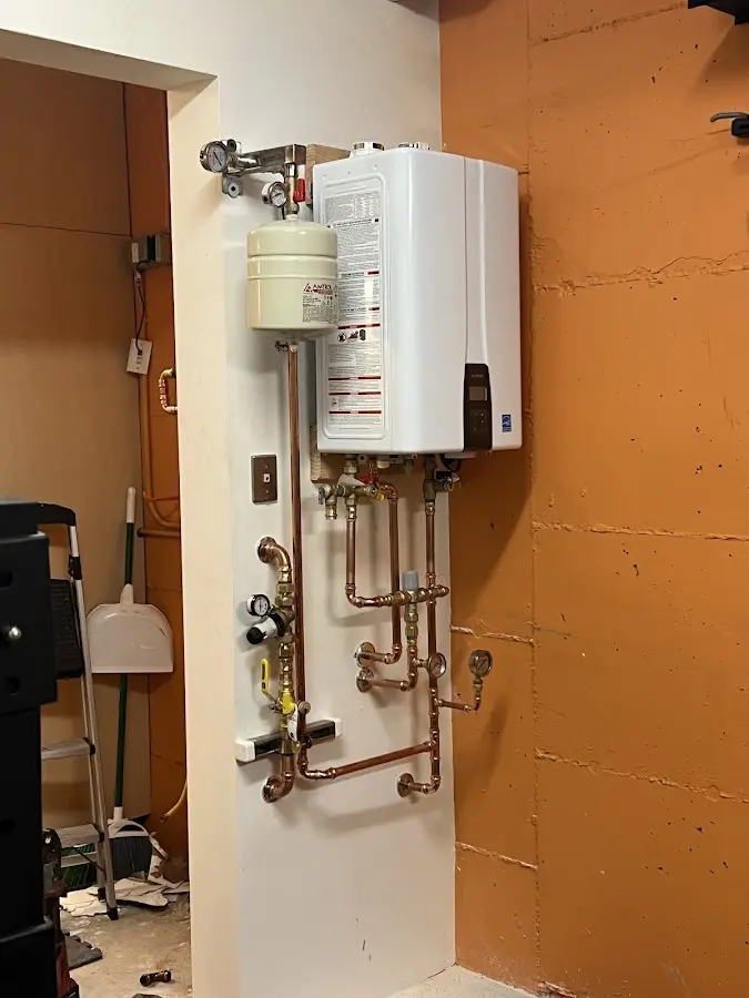 Plumbing technician inspecting water heater connections in Nahant